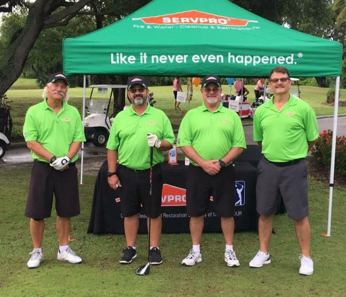 A SERVPRO tent with four men standing in front of it. 