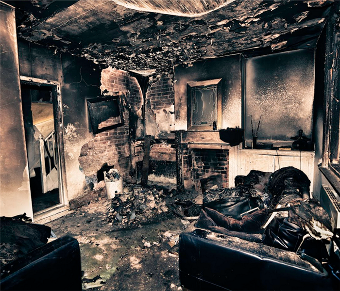 a fire damaged living room with soot and debris everywhere