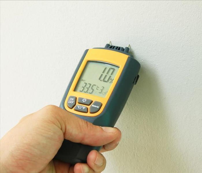 moisture meter with probes on wall