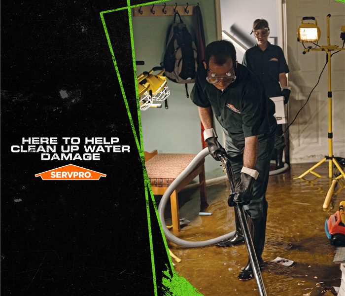 SERVPRO crew extracting water from a flooded home with the caption: "HERE TO HELP CLEAN UP WATER DAMAGE"
