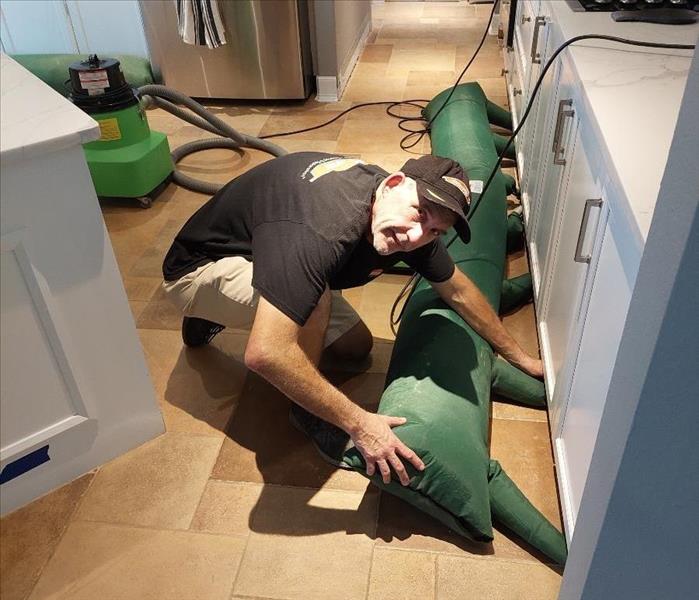 SERVPRO tech setting up equipment in kitchen